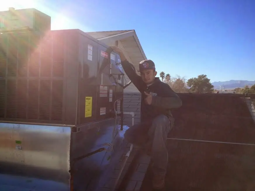 HVAC technician performing AC Tune-Up on a rooftop unit in Harrodsburg