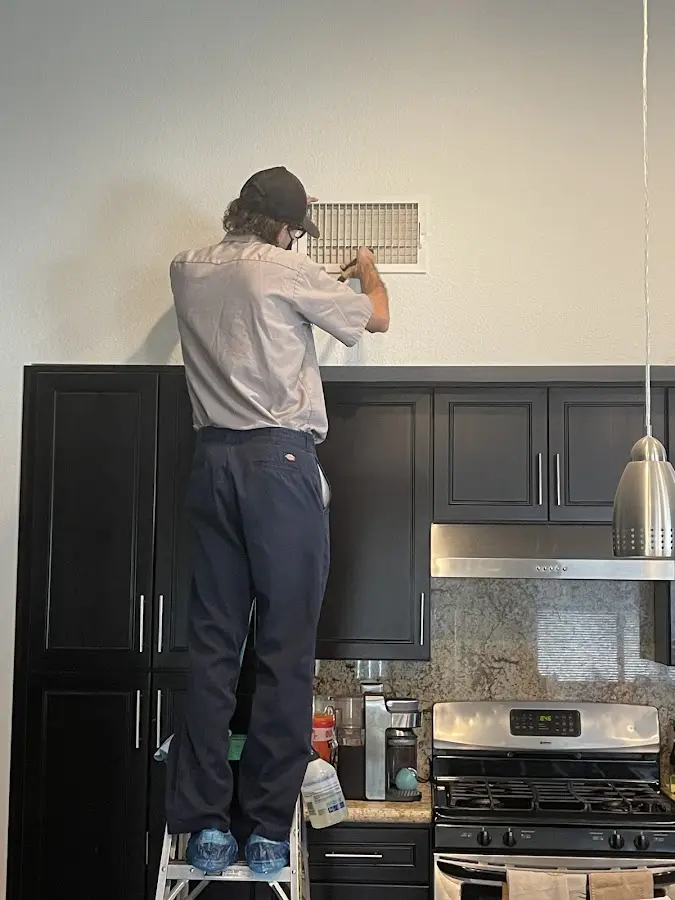 Technician inspecting an air vent during HVAC service in Harrodsburg